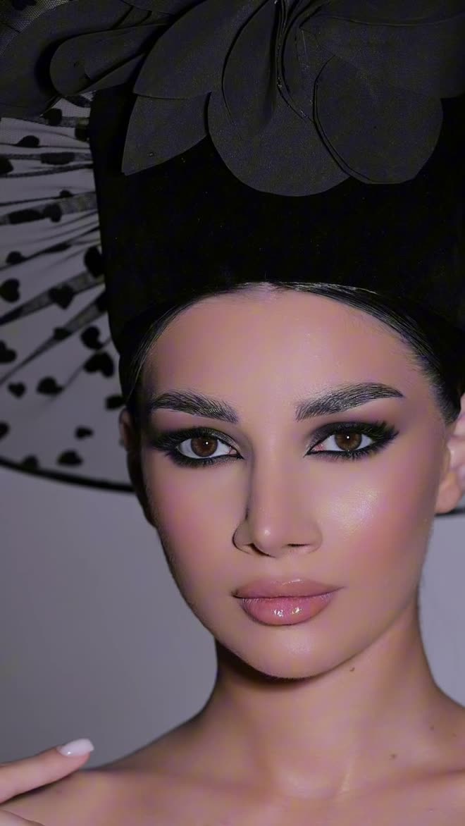 Editorial makeup with a smoky eye, photographed with a black couture headpiece and veil